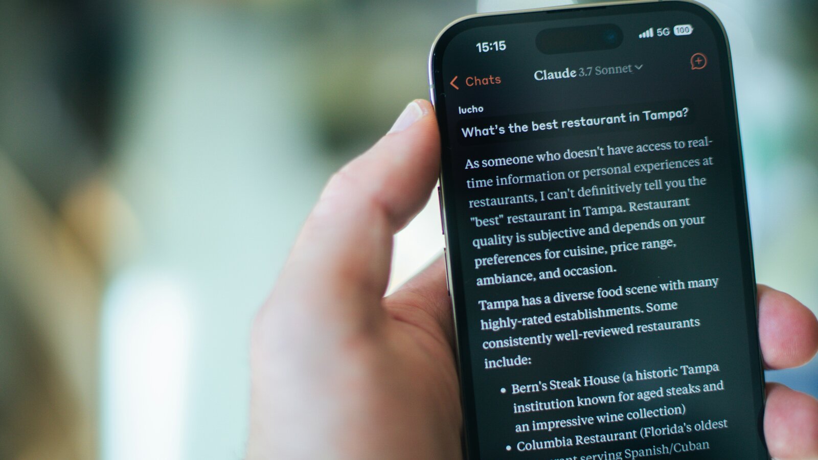 Persona usando Claude AI en su iPhone consultando información en tiempo real