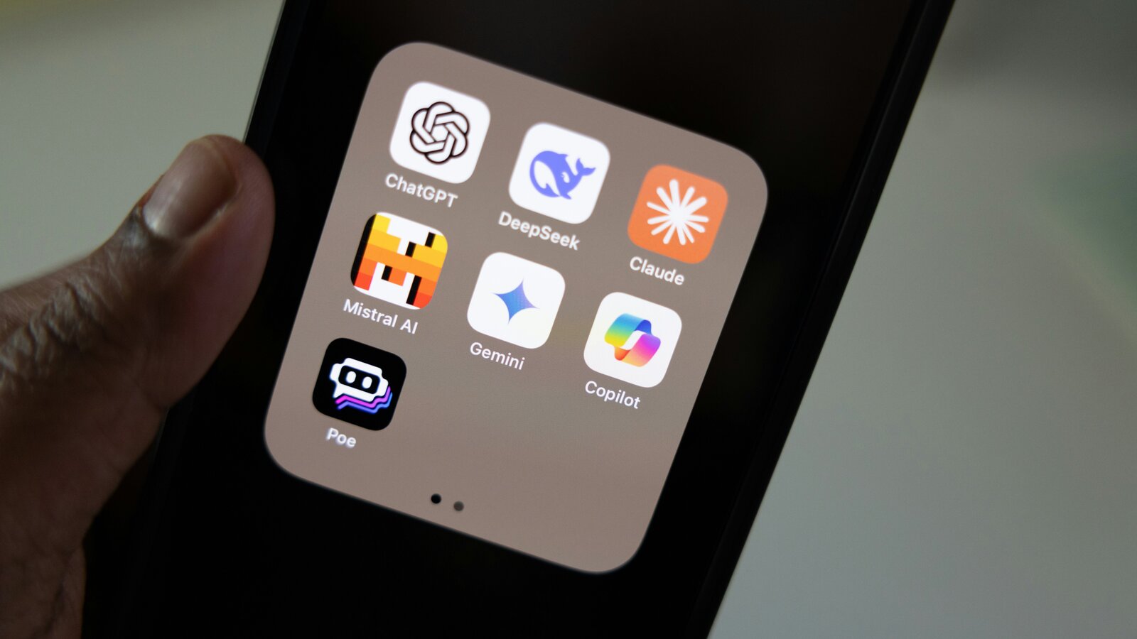 Carpeta de apps de IA en iPhone mostrando ChatGPT, DeepSeek, Claude, Mistral, Gemini, Copilot y Poe